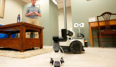 A robot operated by Shehab Attia, a robotics engineer at Hello Robot, reaches to pick up a TV remote during a demonstration at the University of New Hampshire, April 21, in Durham, N.H.