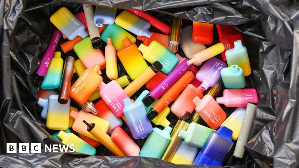 A pile of brightly coloured disposable vape pods fill a black plastic bag.