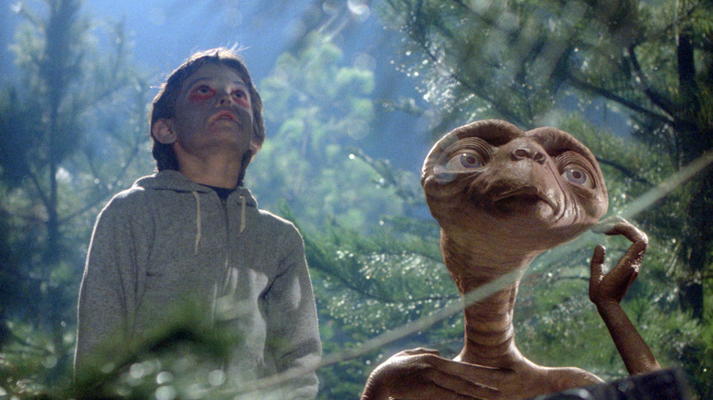 Elliott and E.T. standing in the woods in E.T. the Extra-Terrestrial