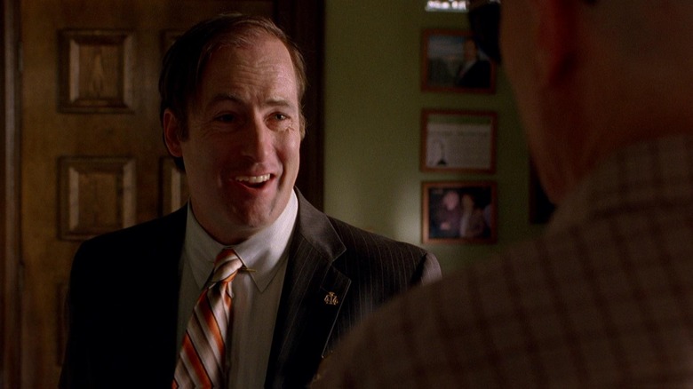 Bob Odenkirk as Saul Goodman smiling at Bryan Cranston as Walt in Breaking Bad