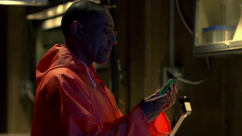 Giancarlo Esposito as Gus in a hazmat suit holding a box cutter in Breaking Bad
