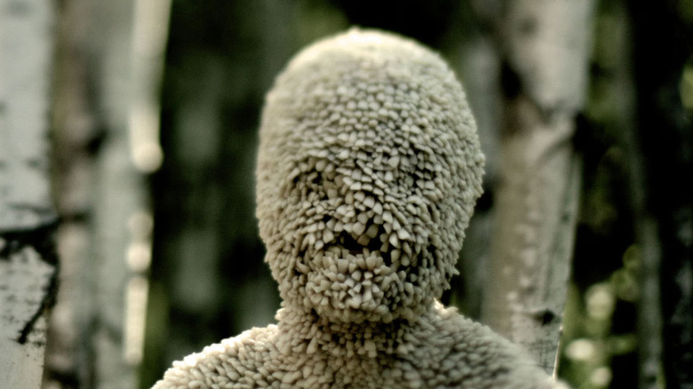 A person made of teeth stands in a forest in Channel Zero