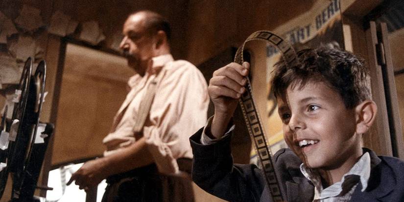 A young boy looking at a film reel in Cinema Paradiso