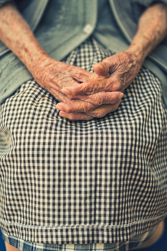 Wrinkled hands resting on lap dementia care expert