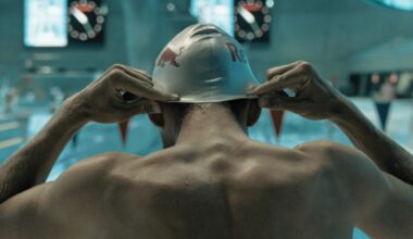 A swimmer putting on his swim cap.