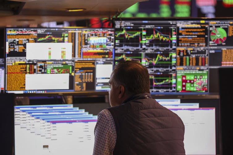 A trader looks over stock charts on the New York Stock Exchange floor.