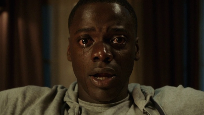 Daniel Kaluuya as Chris Washington in Get Out, looking dead ahead with his mouth hung agape and tears streaming from his wide-open eyes.
