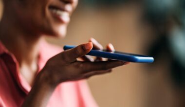 Closeup of a smiling woman speaking into her smartphone
