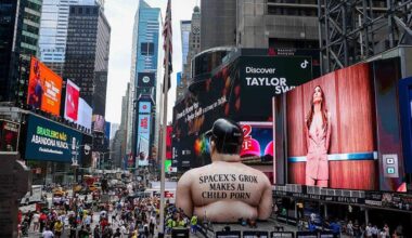 A giant inflatable effigy of Elon Musk in the middle of New York's Times Square, with the words "SpaceX's Grok makes AI child porn."