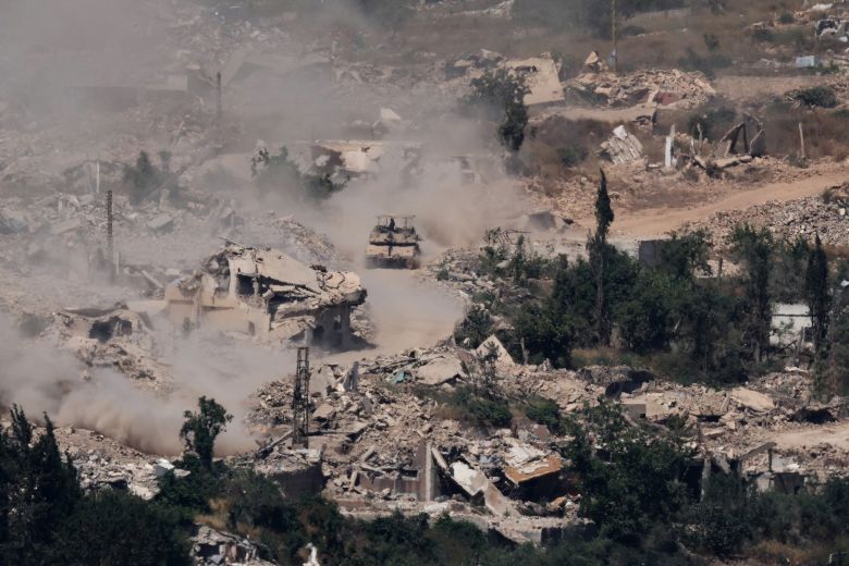 This picture taken from a position in the Upper Galilee in northern Israel, near the Israel-Lebanon border, shows Israeli tanks driving past destroyed buildings in southern Lebanon on June 17, 2026.