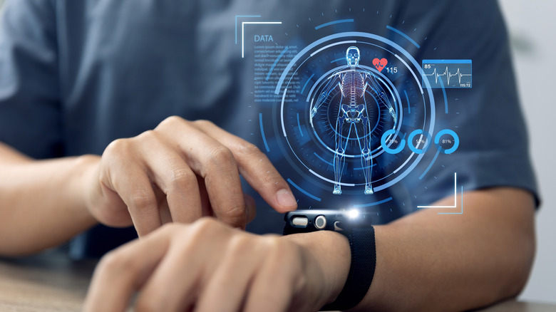 A man interacts with his smartwatch, a holographic display of a human floats above the screen.