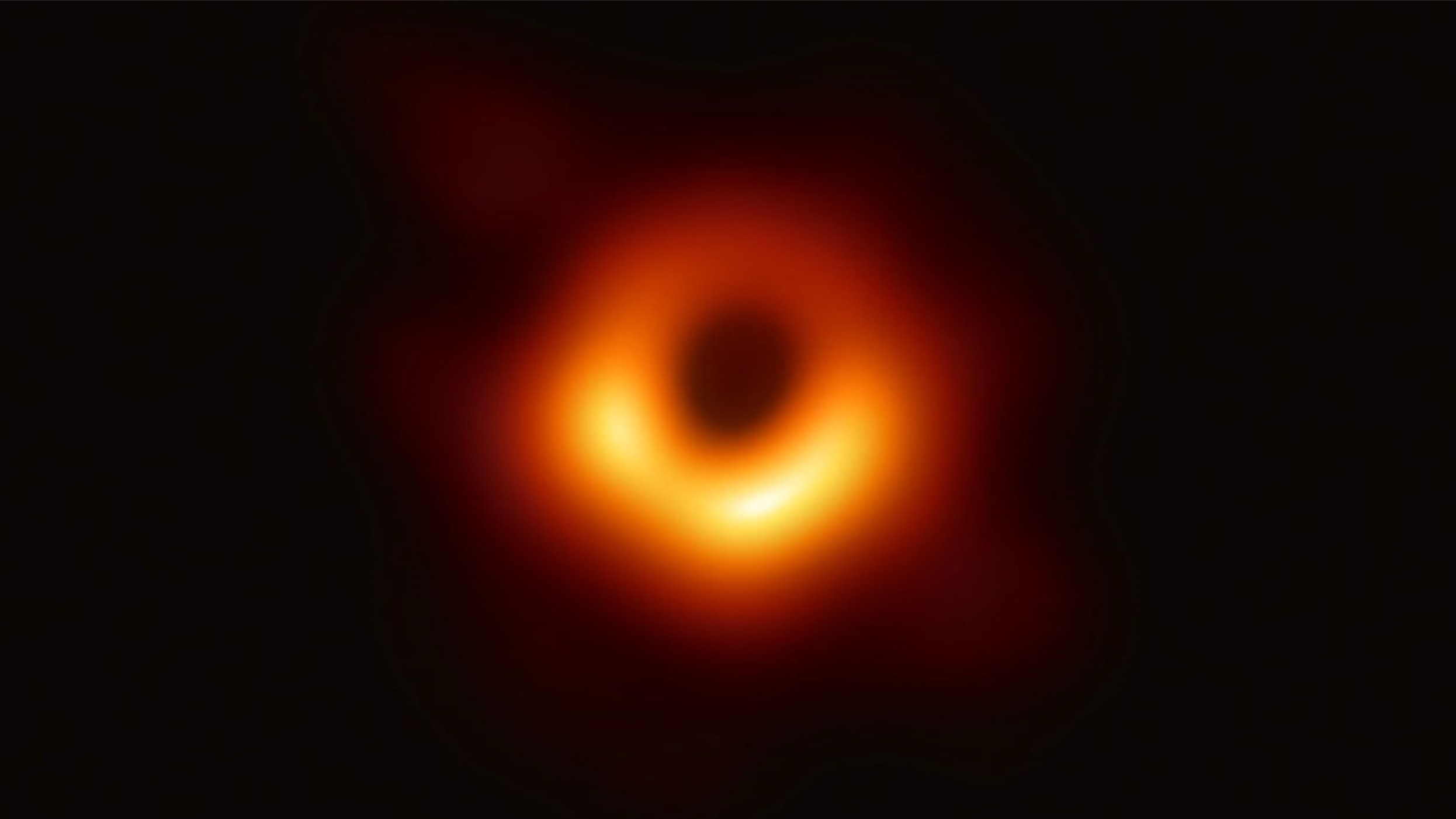 A fuzzy orange doughnut-shape object against a dark background.