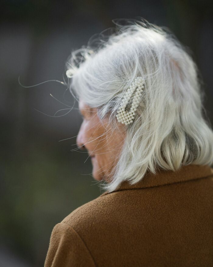 Side profile of elderly woman with white hair and dementia