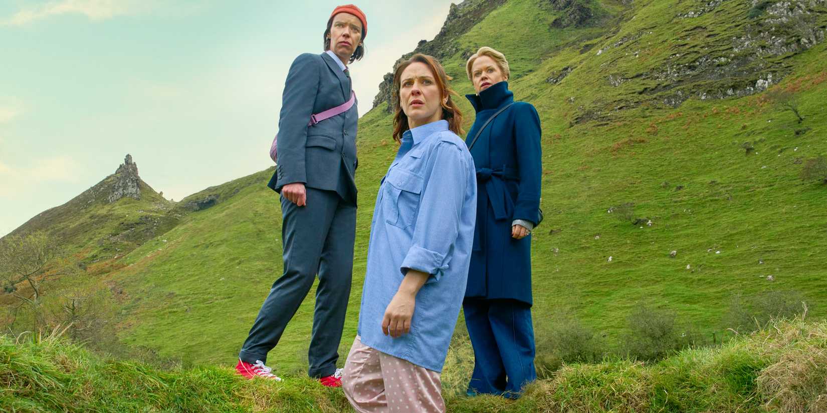 Roisin Gallagher as Saoirse, Caoilfhionn Dunne as Dara and Sinead Keenan as Robin on grassy hills in How to Get to Heaven from Belfast.