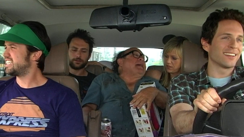 The Gang drives an intoxicated Frank, who is holding boxed wine and a can, on It's Always Sunny in Philadelphia.