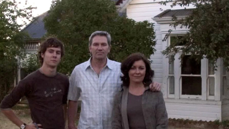 Rosie Traynor as June Palmer, David Pledger as Russell Palmer, and Martin Sharpe as Mathew Palmer in Lake Mungo, posing for a shot in front of their house, looking at the camera.