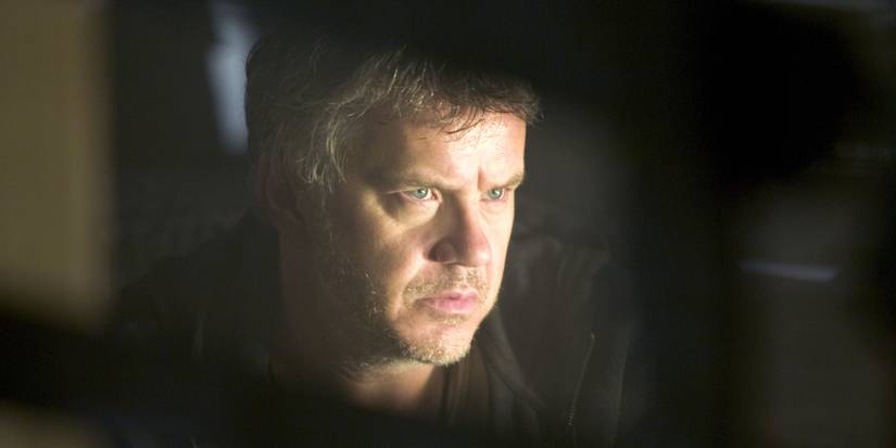 WAR OF THE WORLDS - 2005, Tim Robbins scowling in a dark room