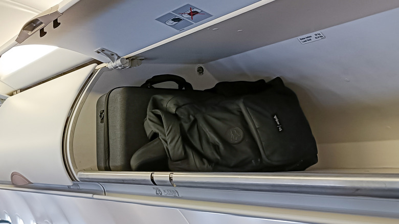 Luggage in an overhead bin on a plane.