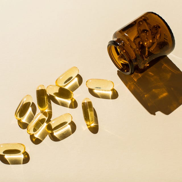 Omega 3 fish oil capsules and a glass bottle on a beige background. omega 3 fish oil capsules and a glass bottle on a beige background