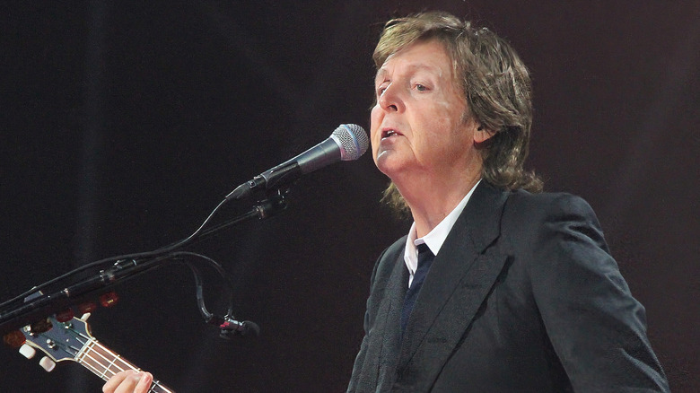 Paul mccartney onstage with microphone and bass