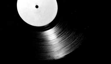 A close-up of a vintage vinyl record in black and white, emphasizing its grooves.