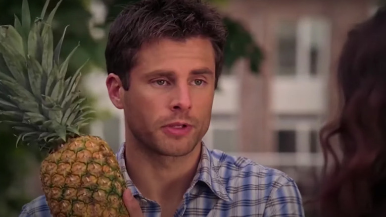 Shawn holding a pineapple while speaking