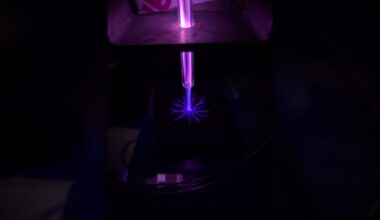 A close up of a blue laser in a dark room.