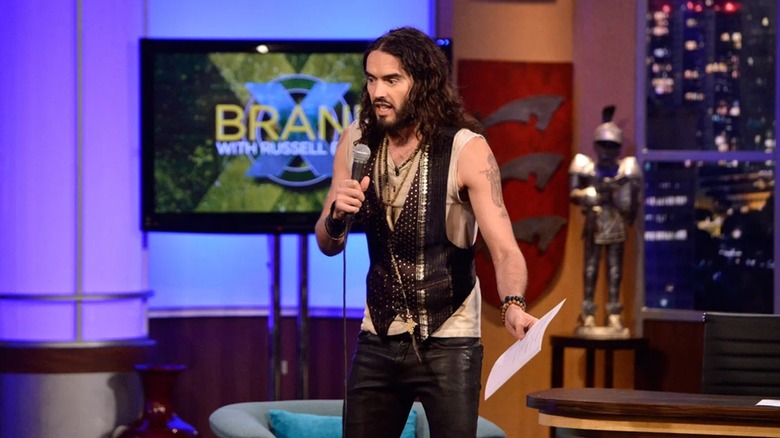 Russell Brand wielding some papers while hosting Brand X With Russell Brand (2012)