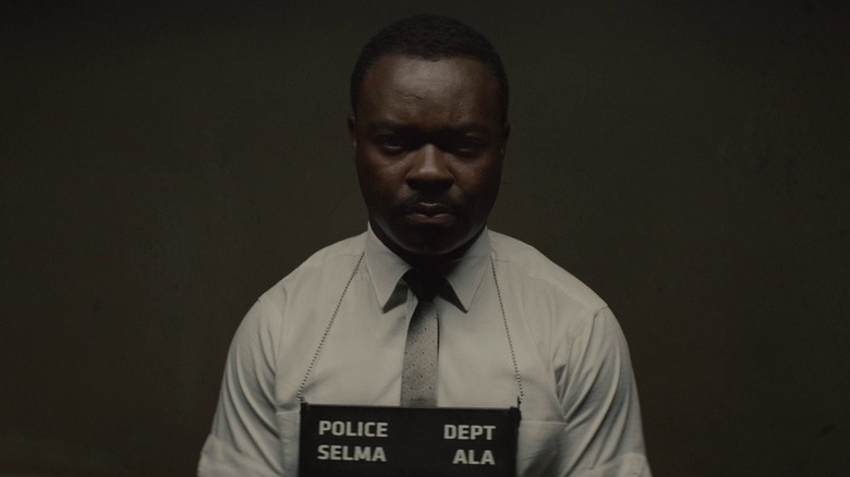 Martin Luther King, Jr. (David Oyelowo) stands solemnly for a police booking photo in Selma