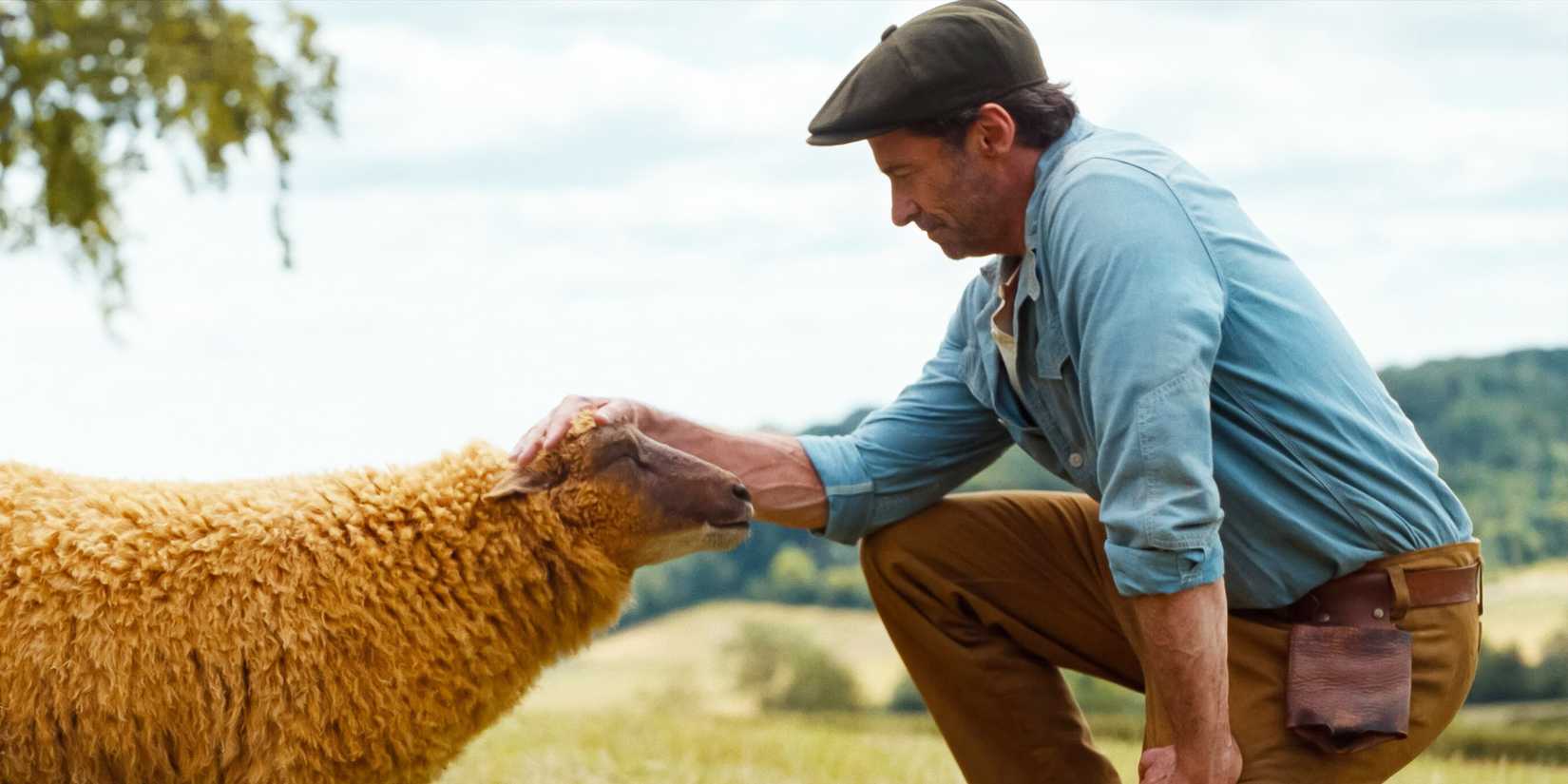 Hugh Jackman as George the shepherd petting one of his sheep in The Sheep Detectives