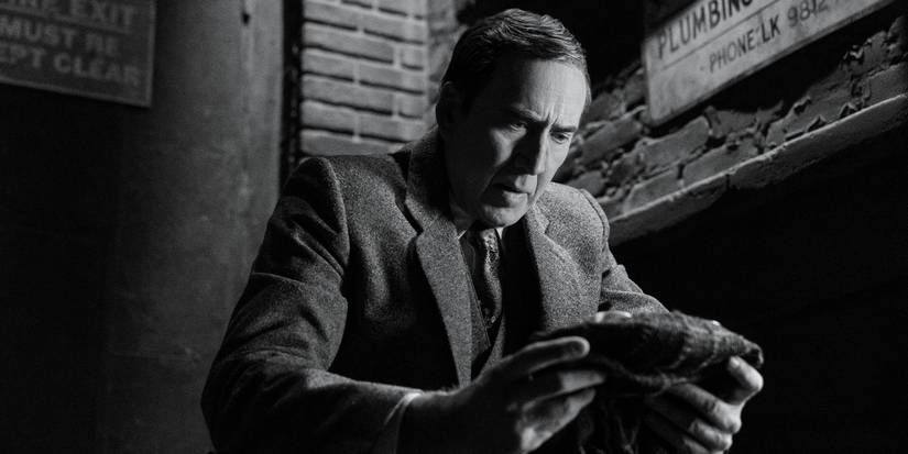 Nicolas Cage as Ben Reilly holding The Spider mask in his hands in Spider-Noir