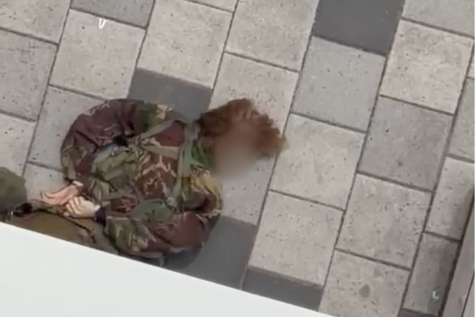 Man with face blurred lying unconscious on the groun
