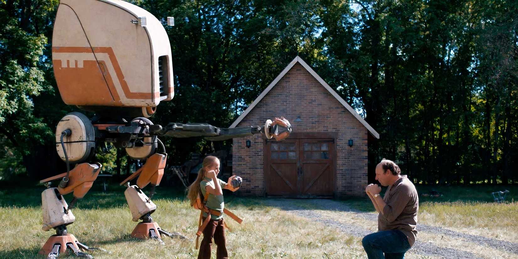 A large robot standing behind a little girl and mimicking her movements, while she mimics an older gentleman's boxing moves, in the series Tales from the Loop.
