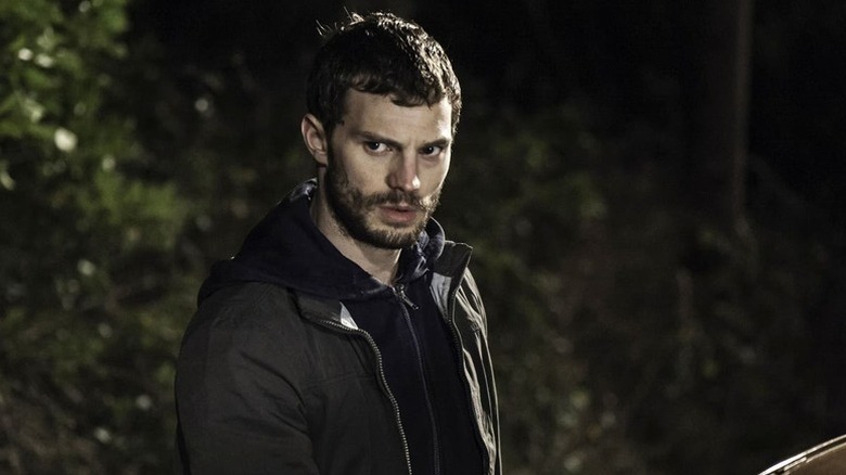 Paul Spector (Jamie Dornan) stands in a forest in The Fall