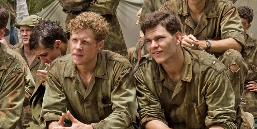 Ashton Holmes and Josh Helman sit among other soldiers, listening to instructions, in The Pacific.