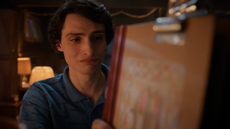 Finn Wolfhard as Mike crying while he puts his D&D folder on a shelf in Stranger Things