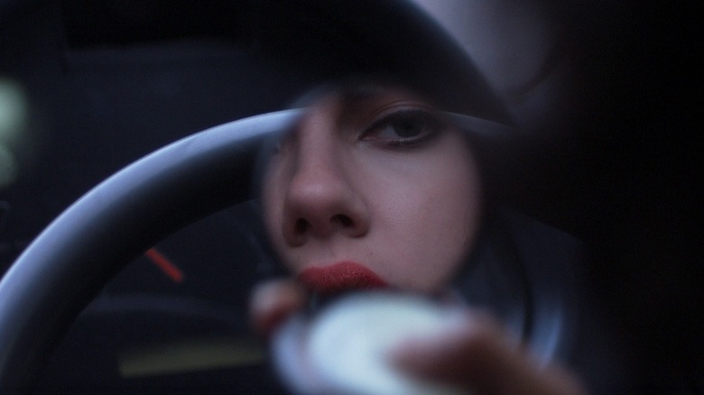 Scarlett Johansson as The Female in Under the Skin, as seen via the small view from a compact mirror in which she is looking at herself.