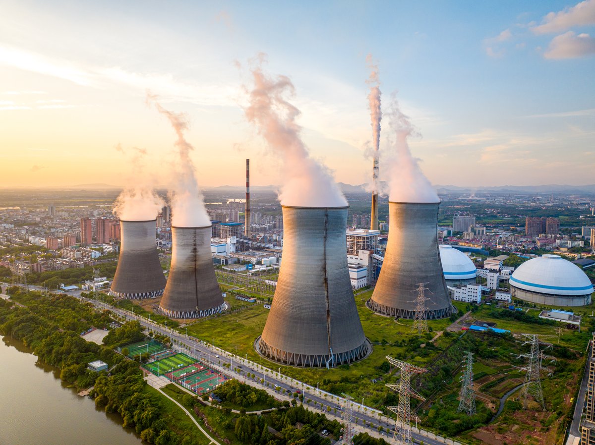 Smoke leaving the chimneys of a power plant.