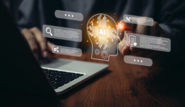 A person using a laptop and a graphic of a human head with the word AI written inside it.