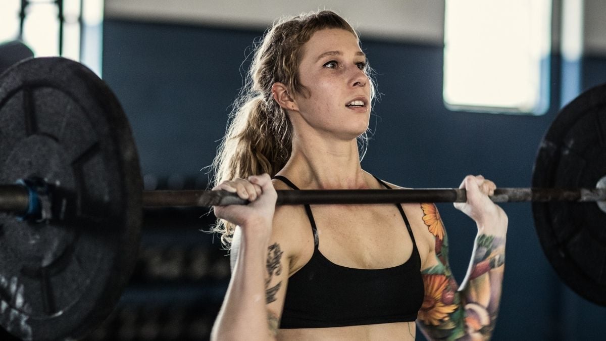 A young women lifting weights, to illustrate that strength training is good for longevity 
