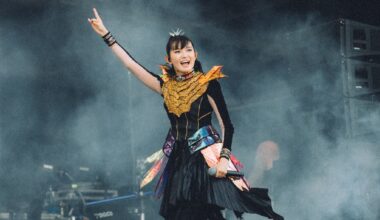 Babymetal smiling and throwing the horns