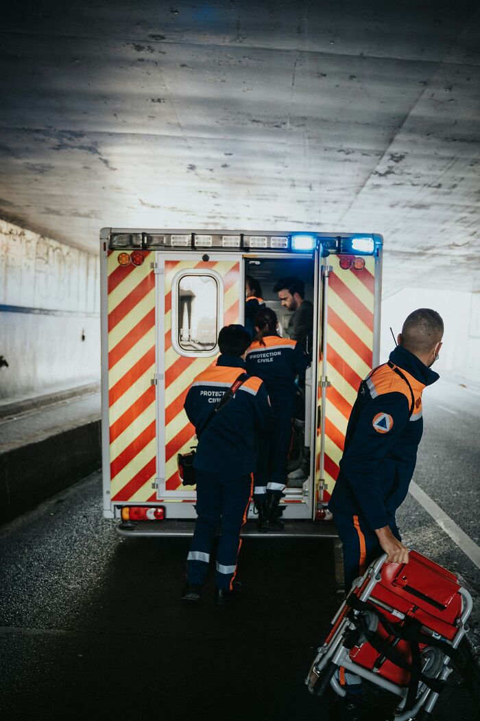 Emergency medical personnel loading a stretcher into the back of an ambulance, showing what doctors do when a patient is faking it.