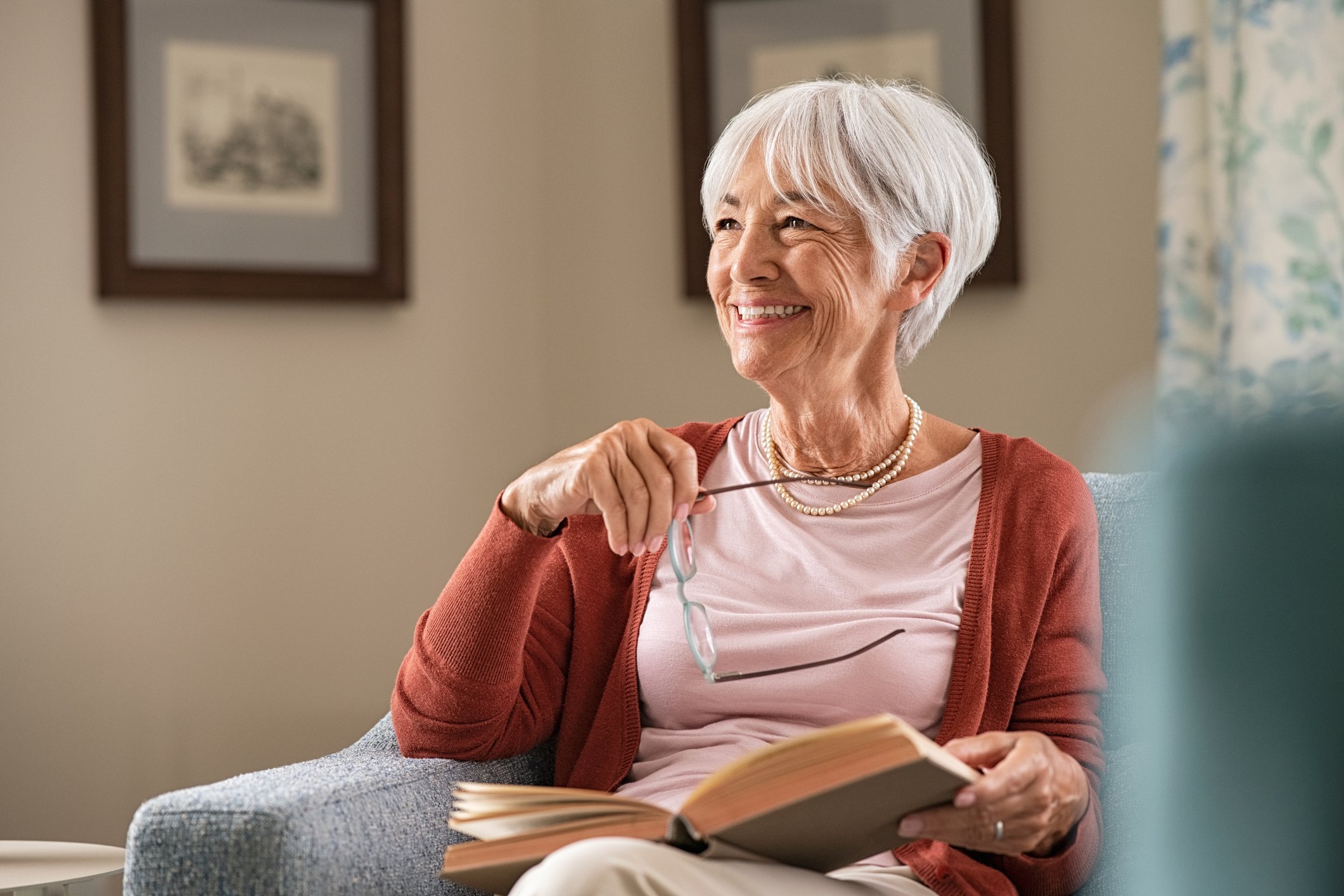 A smiling person holding a book.