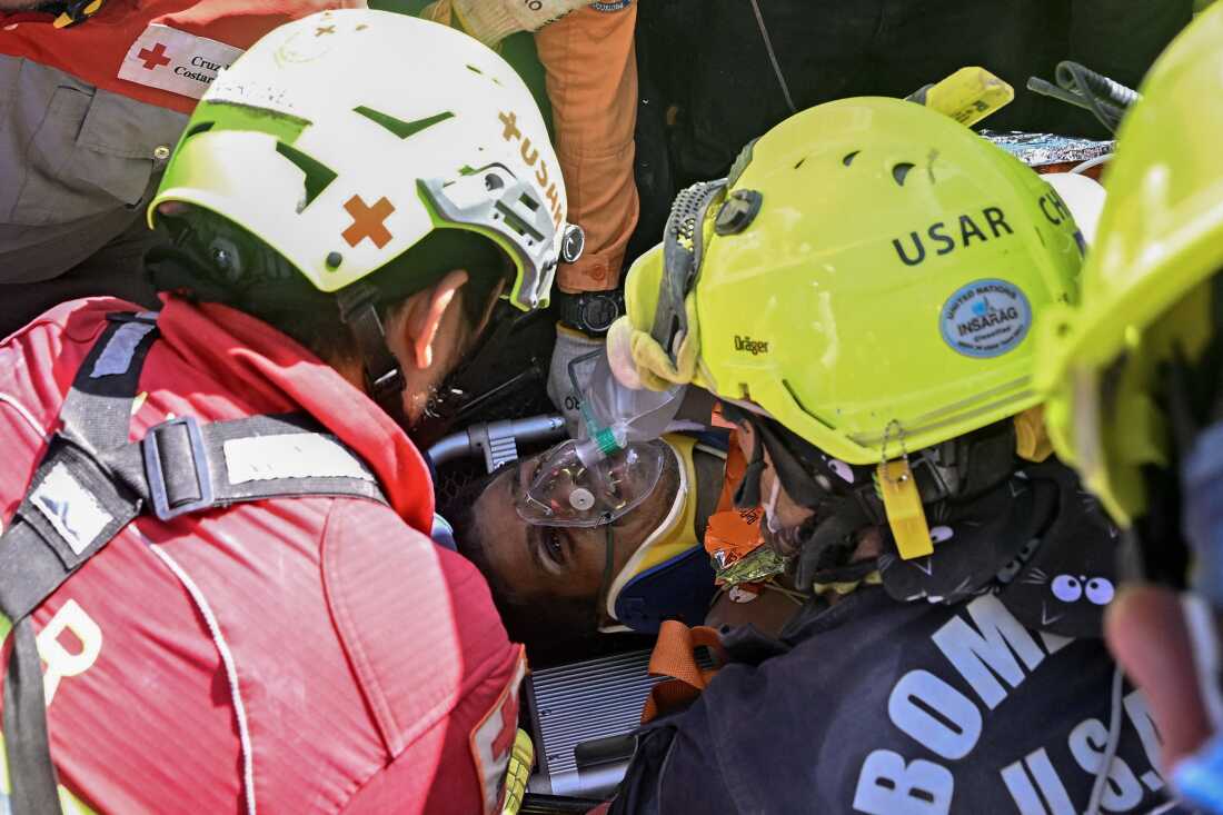 An international rescue team assists Hernan Gil, a survivor of Venezuela's twin earthquakes, in Catia La Mar, La Guaira State, Venezuela on July 2, 2026, eight days after the quake. Hernan Gil, a 43-year-old security guard, had been buried in the booth of the seven-story building where he worked in Catia La Mar, a coastal area in the state of La Guaira, which was devastated by the disaster.