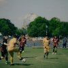 Men play soccer on a field.