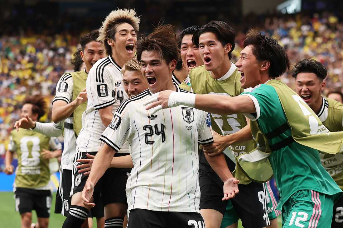 Kaishu Sano (#24) of Japan celebrates with teammates after scoring the team's first goal during Japan's match against Brazil on June 29 in Houston.