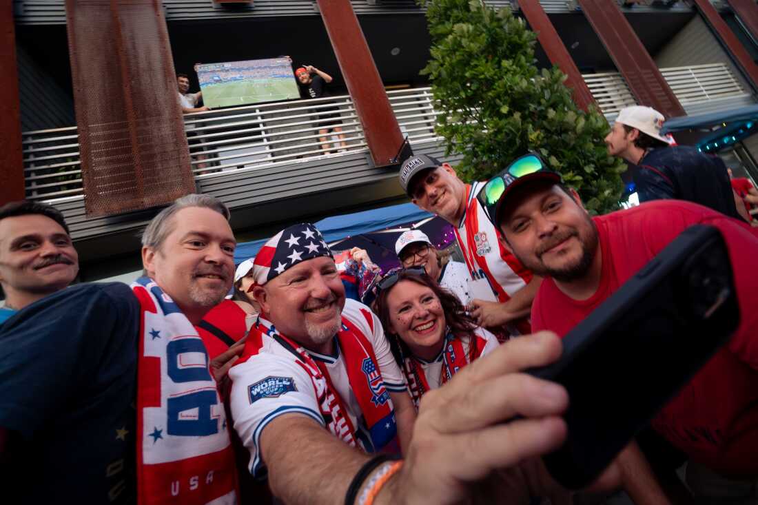 American Outlaws St. Louis Chapter President Kevin Marshall, second from left, takes a selfie alongside club members and St. Louisans who set up their TV for hundreds to watch after a power outage cut the USMNT vs. Paraguay stream outside Amsterdam Tavern on Friday, June 12, in south St. Louis.