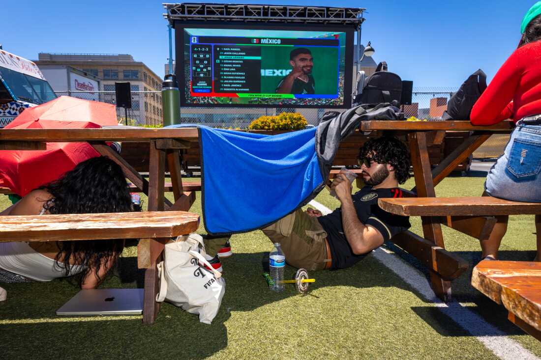People find shade under tables, benches and blankets at a Mexico vs. South Africa World Cup watch party at SPARK Social SF in San Francisco on June 11.