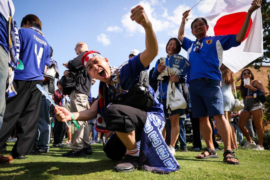 Toshiki Hayashi, center, and other fans cheer for Japan at a Paint It Blue event before the World Cup game Wednesday, June 24, at Harwood Park in Dallas.