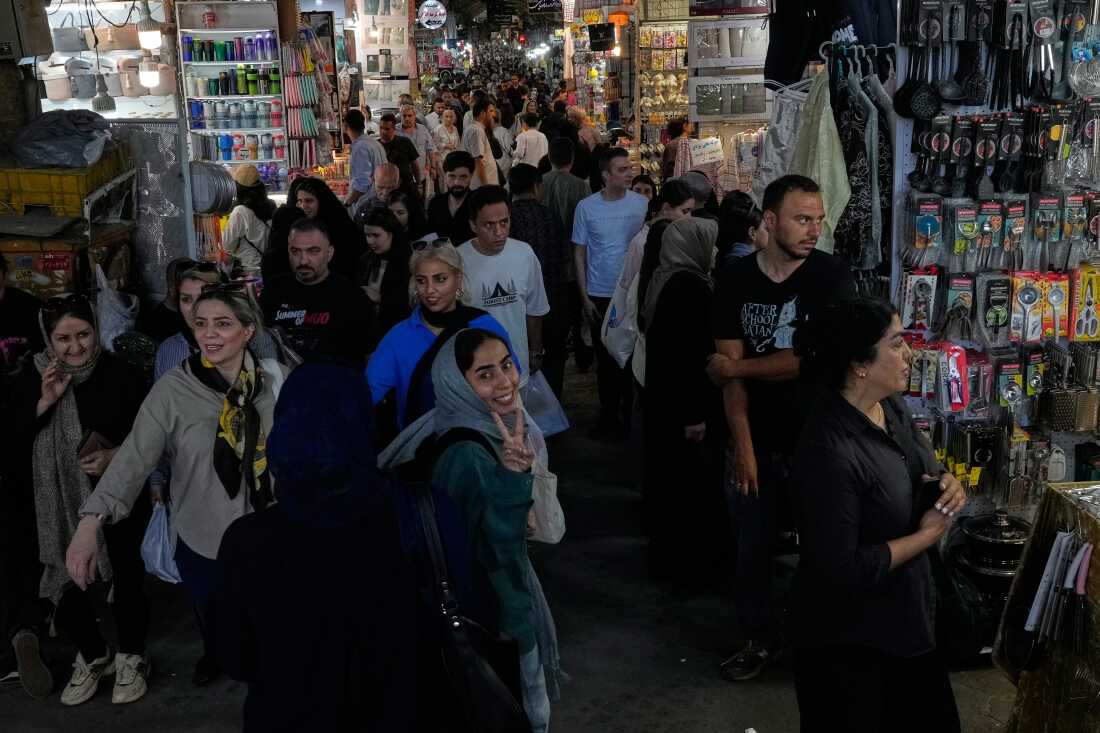 A woman flashes a victory sign while walking at Tehran's traditional main bazaar, Iran, Thursday, July 16, 2026.